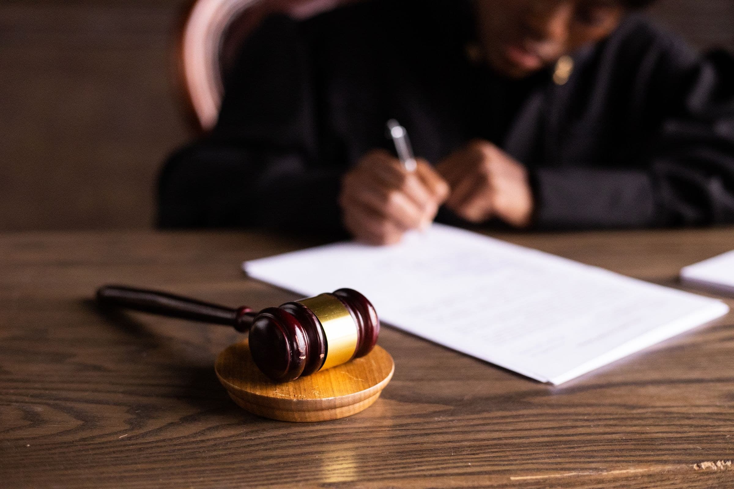 A judge signing documents at the bench